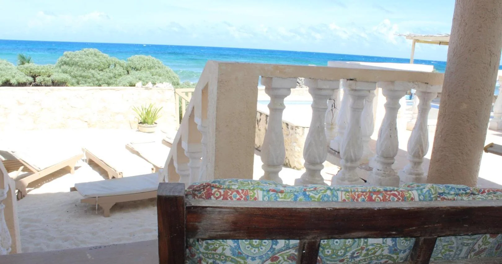 Terrasse à balustrade blanche, transats et mer turquoise